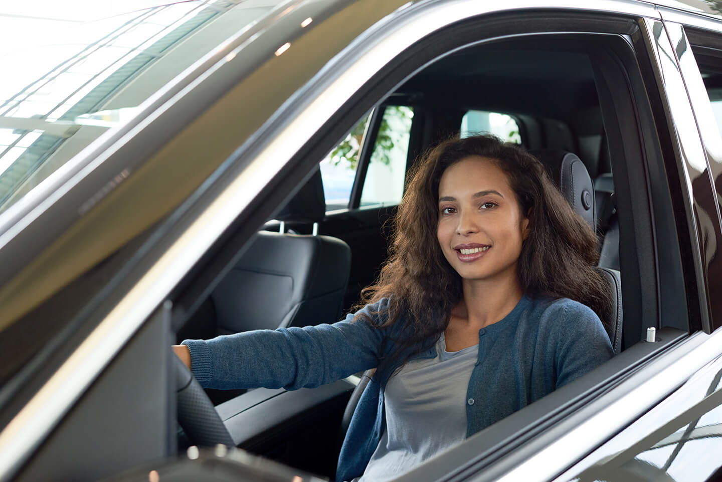 Smiling driver behind the wheel of her SUV