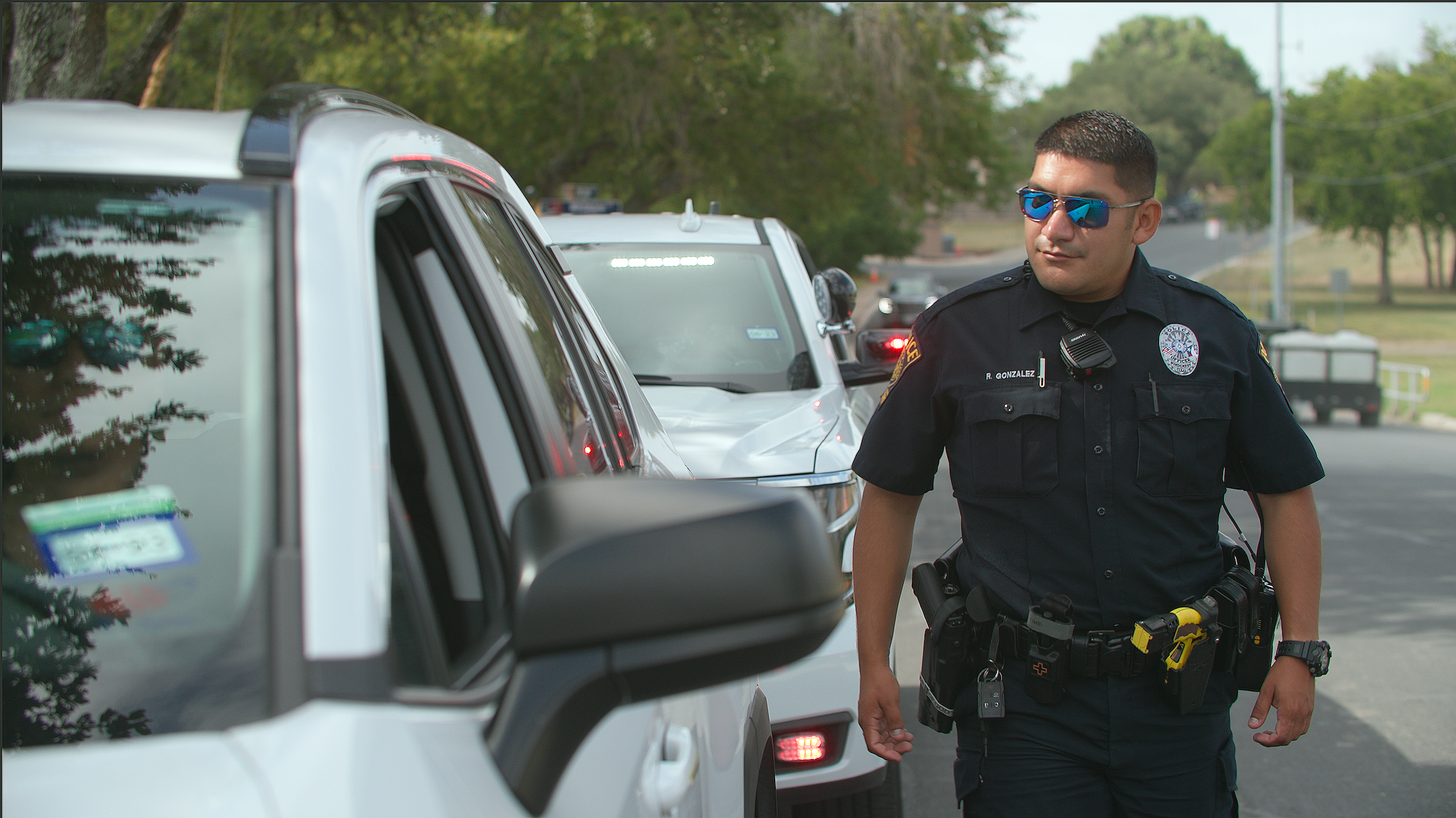 Image of officer walking up to window of car pulled over in front of police car